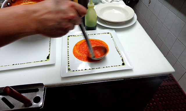 Pablo puts his special tomato sauce as the base for the dish.